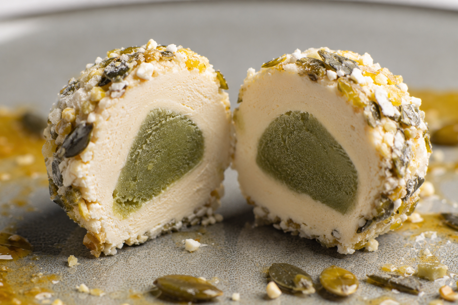 Aufgeschnittener Eisknödel mit Kürbiskernhülle und grünem Kern aus nächster Nähe